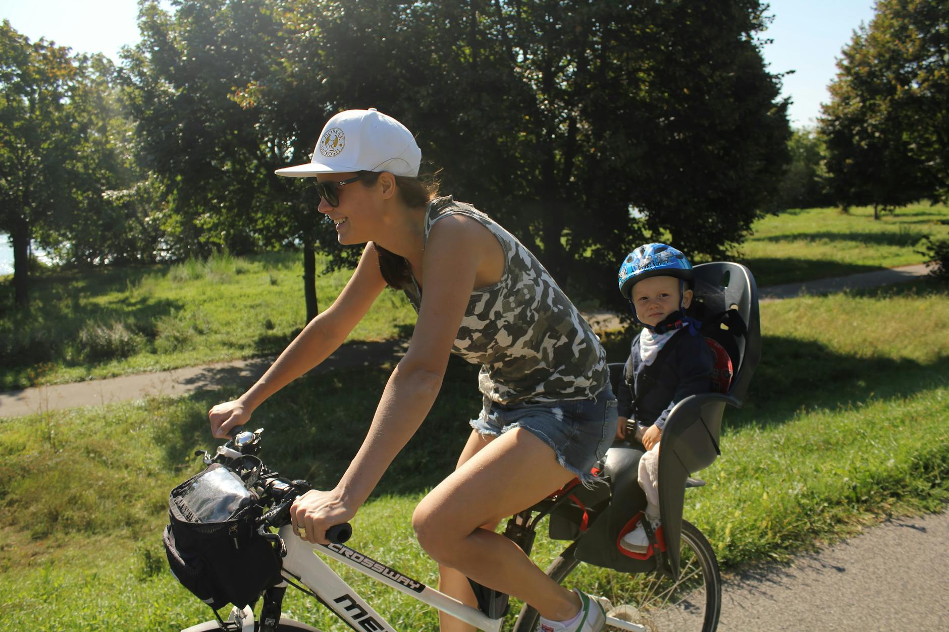 Rodzinne wycieczki rowerowe po Gorzowie: jak zadbać o bezpieczeństwo i kondycję dziecka Mama z dzieckiem jadą na rowerach po parku w słoneczny dzień