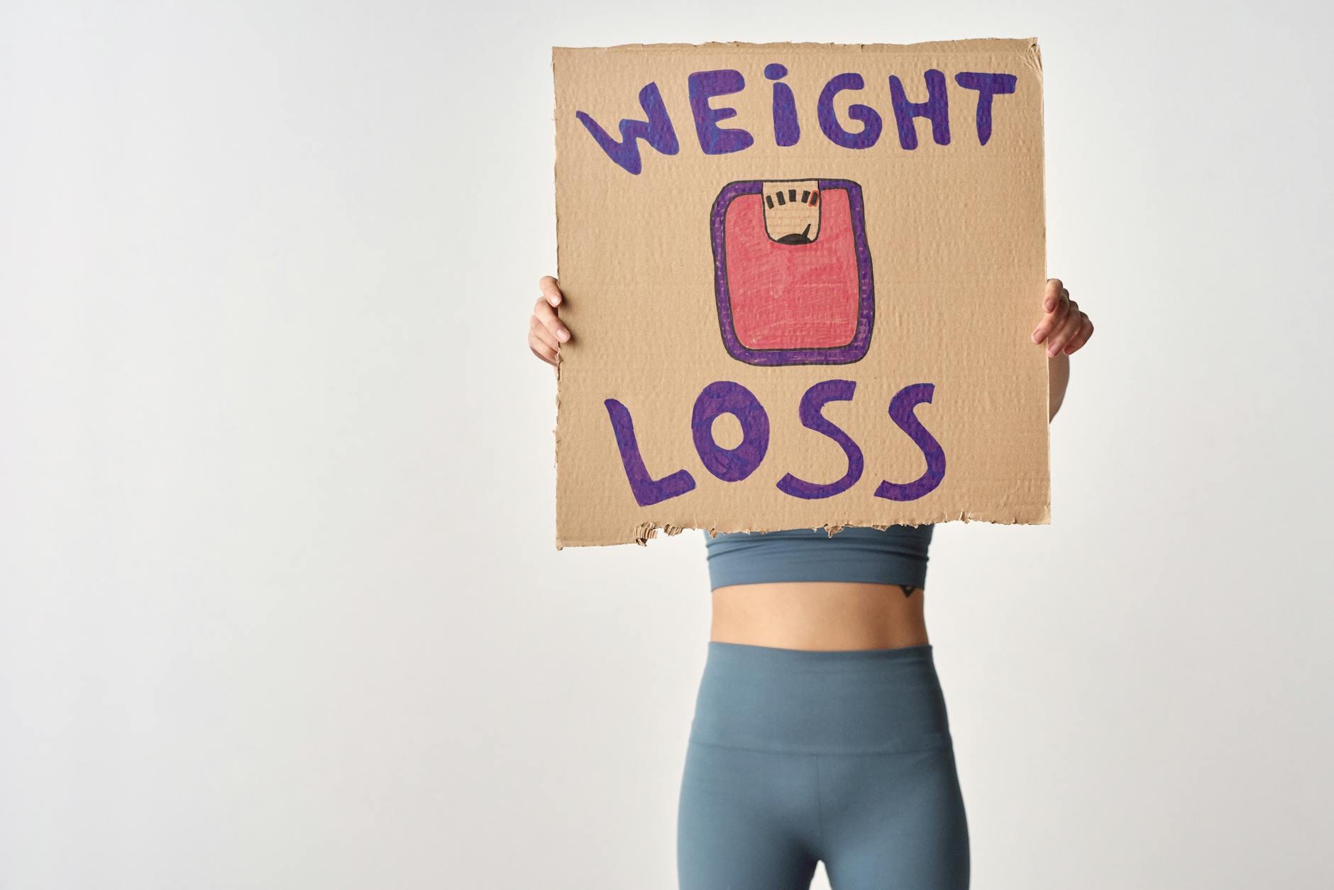 Osoba trzyma kartkę z napisem weight loss jako motywacja do odchudzania