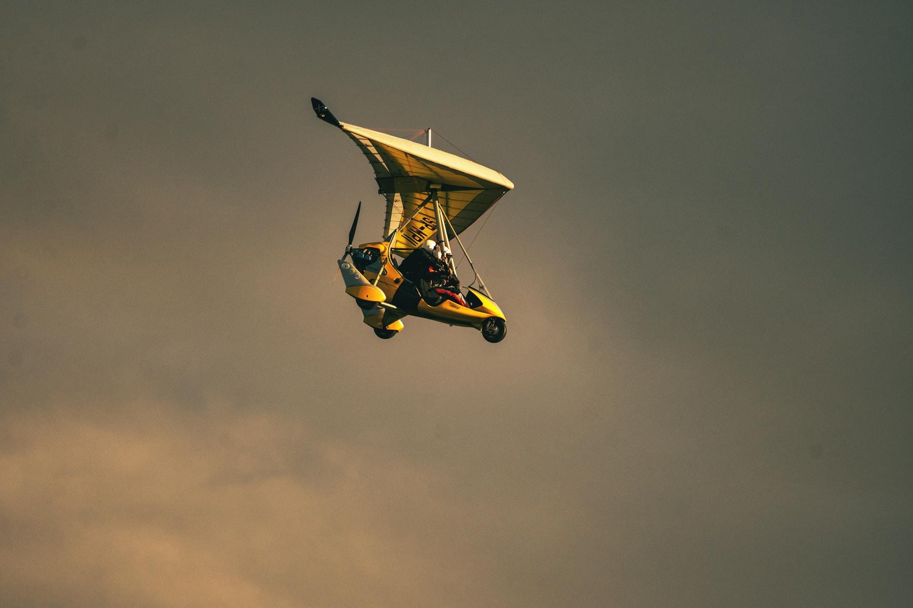 Ultralight samolot szybuje o zachodzie słońca nad horyzontem