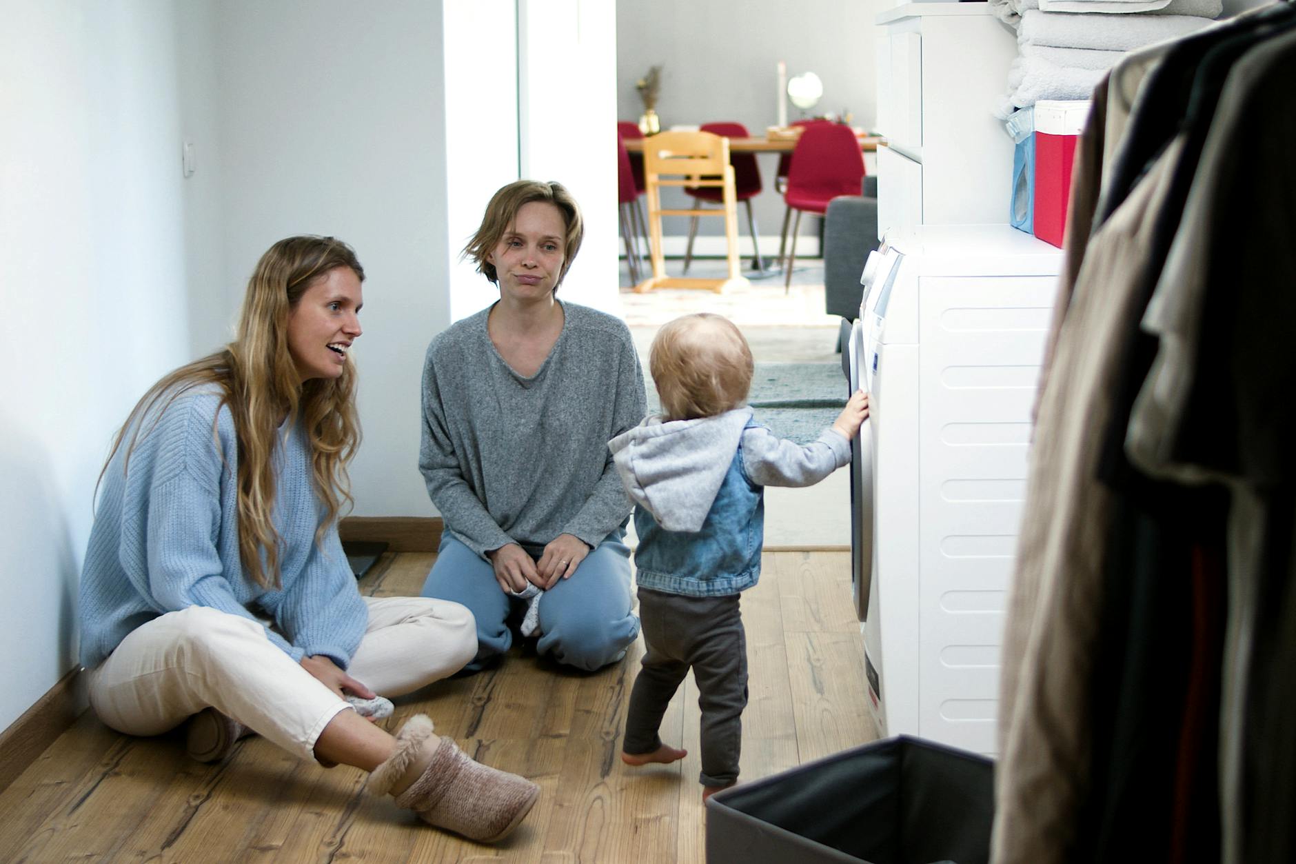 Mama i opiekunka bawią się z maluchem w przytulnym salonie
