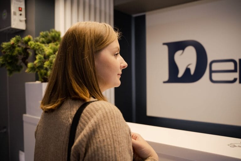 Kobieta czeka w recepcji gabinetu dentystycznego