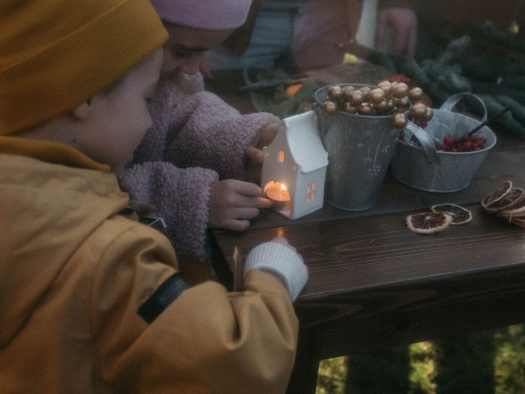 Dzieci wykonują zimowe ozdoby przy stole warsztatowym